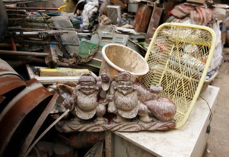 A muddy wooden Daikokuten gods statue is seen on household waste in a flooded area in Mabi town in Kurashiki, Okayama Prefecture, July 13, 2018. REUTERS/Issei Kato