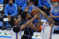 Sacramento Kings forward Marvin Bagley III, center, reaches for a rebound with Oklahoma City Thunder center Moses Brown, left, and forward Darius Bazley (7) in the second 117half of an NBA basketball game Tuesday, May 4, 2021, in Oklahoma City. (AP Photo/Sue Ogrocki)