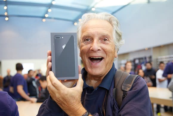 An excited customer holds a new iPhone 8 Plus on the day of the iPhone 8 launch