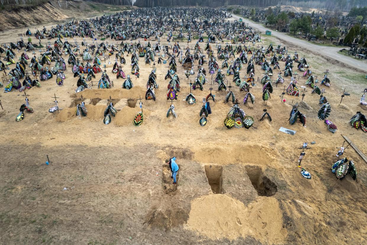 A grave digger prepares the ground for a funeral at a cemetery on April 20, 2022 in Irpin, Ukraine.