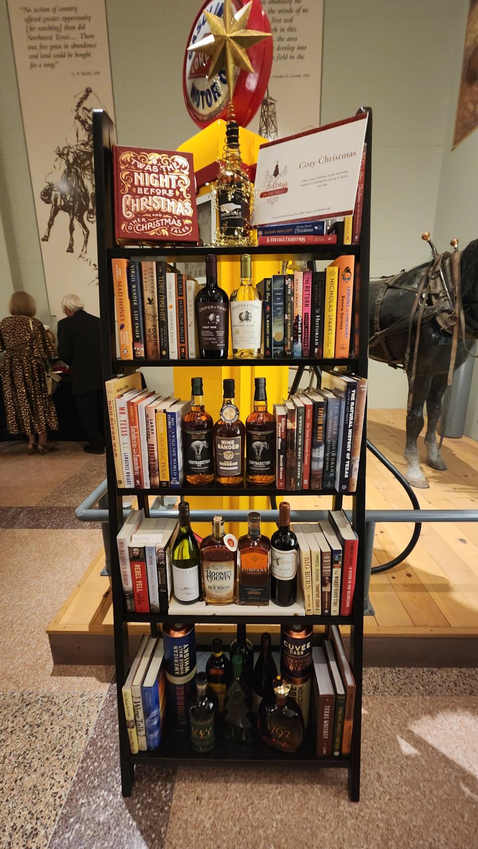 The Cozy Christmas bookcase with books and spirits was among the many unique gifts auctioned off at the "Tree of Tidings" fundraiser Thursday night at the Panhandle-Plains Historical Museum in Canyon.