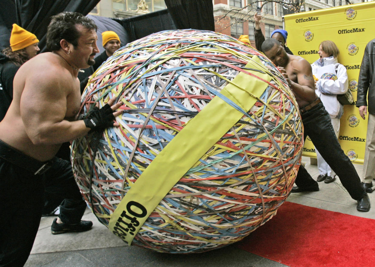 A rubber band ball is pushed to a scale for a weigh-in before its certification by officials from Guinness World records as the world's largest Tuesday, Nov. 21, 2006, in Chicago. The ball, weighing 4,594 pounds, was created by Steve Milton, of Eugene, Ore., using more than 175,000 rubber bands. (AP Photo/Charles Rex Arbogast)