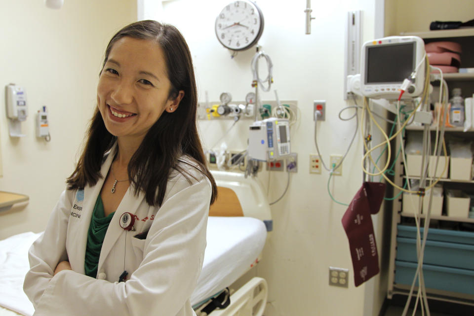 In this Tuesday, Aug. 14, 2012 photo Leana Wen, of Boston, who is doing her medical residency in emergency medicine at Harvard-affiliated Brigham and Women's Hospital and Massachusetts General Hospital, stands in front of a bed in the emergency department at Brigham and Women's, in Boston. Wen chose emergency medicine because the hours are more flexible than those of primary care physicians. (AP Photo/Steven Senne)