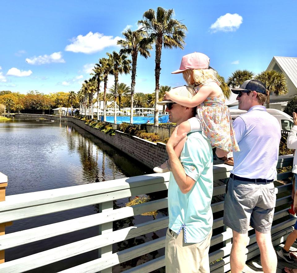 Alex Calder of Atlantic Beach watcees final-round action at the 18th hole of the Atlantic Beach Country Club with his 3-year-old daughter Libby during the final round of the Epson Tour's Atlantic Beach Classic on March 23.