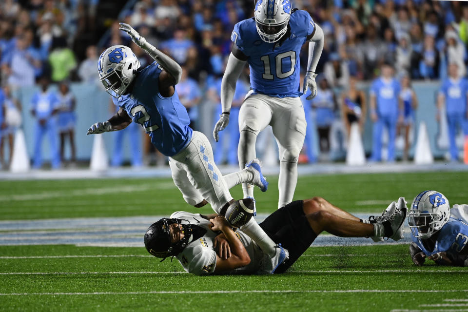 Sep 9, 2023; Chapel Hill, North Carolina, USA; Appalachian State Mountaineers quarterback Joey Aguilar (4) is tackled by North Carolina Tar Heels linebacker Power Echols (23) as defensive lineman Desmond Evans (10) and defensive back Don Chapman (2) help defend in the fourth quarter at Kenan Memorial Stadium. Mandatory Credit: Bob Donnan-USA TODAY Sports