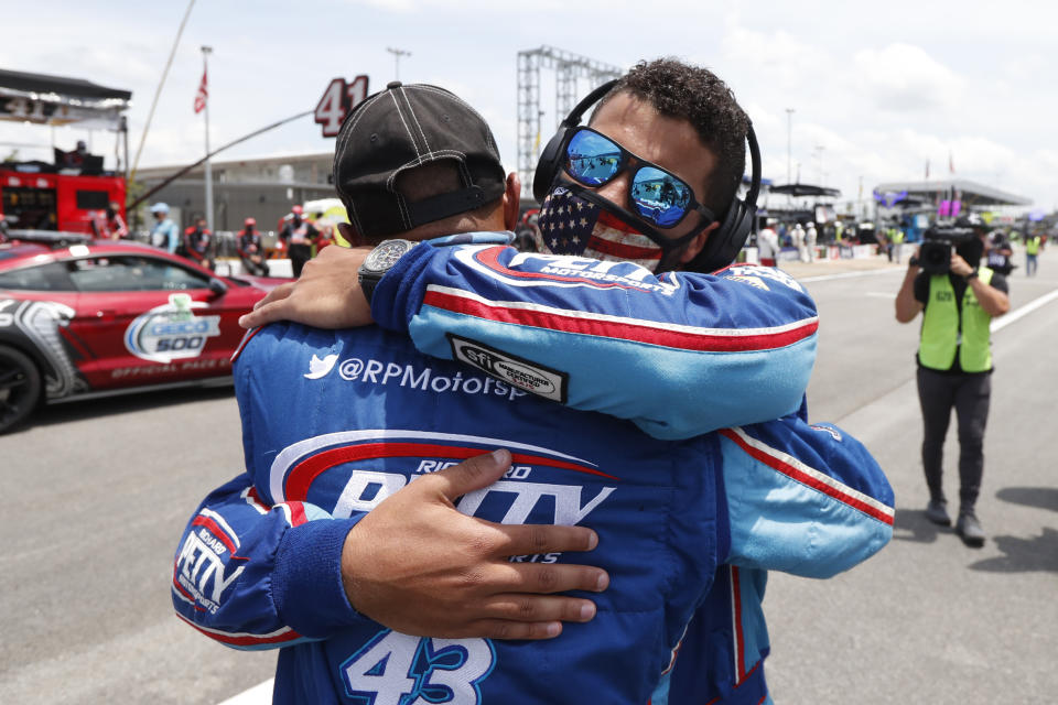 FILE - Driver Bubba Wallace, right, hugs a crew member prior to the start of the NASCAR Cup Series at the Talladega Superspeedway in Talladega, Ala., Monday, June 22, 2020. On June 21, 2020, NASCAR alerted Wallace a noose had been found in his garage stall at Talladega Superspeedway in Alabama. “RACE: Bubba Wallace," is a Netflix docuseries that chronicles the only Black driver at NASCAR's top level and his professional rise and personal role in social justice issues. (AP Photo/John Bazemore, File)