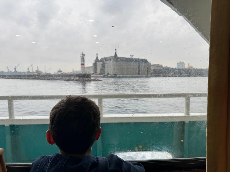 Boy looking at views of Istanbul from ferry window