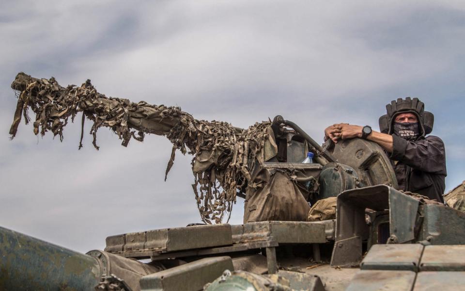 Ukrainian serviceman rides atop a tank near a front line in Mykolaiv region - REUTERS