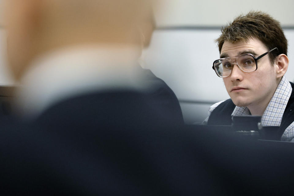 Marjory Stoneman Douglas High School shooter Nikolas Cruz watches as Assistant Public Defender Melisa McNeill gives the defense's opening statement during the penalty phase of his trial at the Broward County Courthouse in Fort Lauderdale on Monday, Aug. 22, 2022. Cruz previously plead guilty to all 17 counts of premeditated murder and 17 counts of attempted murder in the 2018 shootings. (Amy Beth Bennett/South Florida Sun Sentinel via AP, Pool)