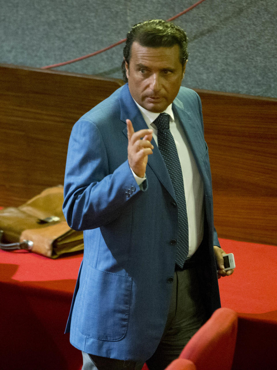 Captain Francesco Schettino leaves the court room of the converted Teatro Moderno theater on the second day of his trial, in Grosseto, Italy, Tuesday, Sept. 24, 2013. The captain of the wrecked Costa Concordia is charged with manslaughter, causing the shipwreck and abandoning ship before the luxury cruise liner's 4,200 passengers and crew could be evacuated on Jan. 13, 2012 when the ship collided with a reef off the Tuscan island of Giglio, killing 32 people. Schettino blames his helmsman for botching a last-minute corrective maneuver that he contends could have prevented the massive cruise ship's collision with the reef. (AP Photo/Andrew Medichini)