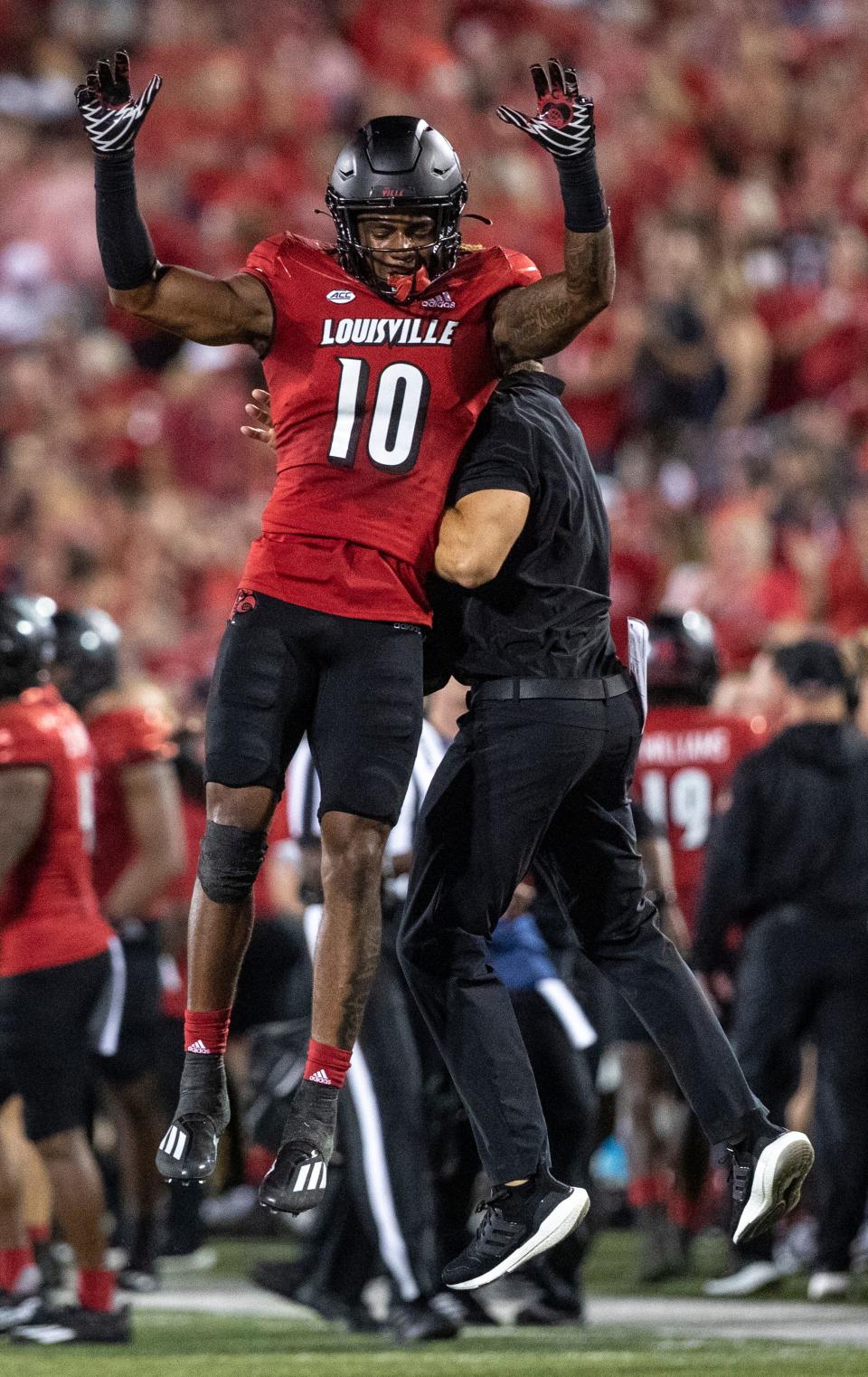 Louisville's Ben Perry celebrates with a coach after a stop against Florida State in September 2022. Perry is set to play a key role for the Cardinals this season.