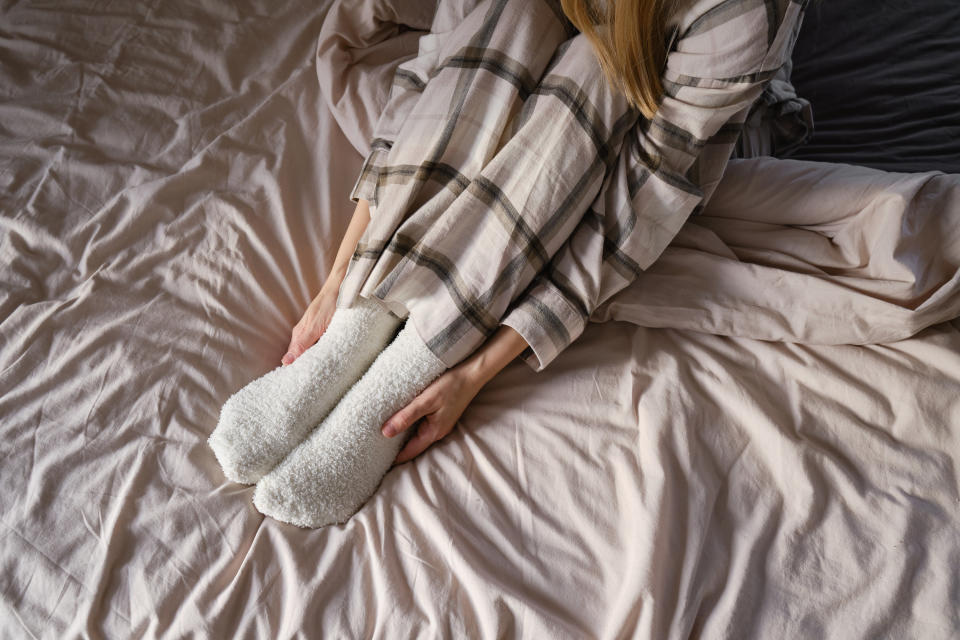 a person sitting on a bed in their pajamas