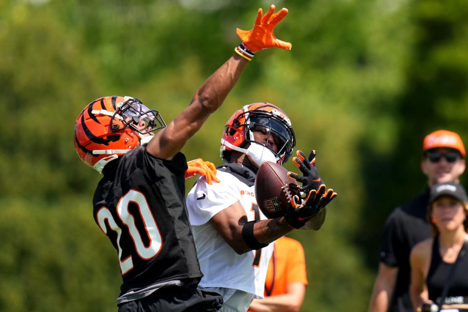 Cincinnati Bengals wide receiver Ja'Marr Chase (1) completes a catch down the sidelines as Cincinnati Bengals cornerback DJ Turner II (20) defends during NFL training camp practice, Monday, July 31, 2023, in Cincinnati.