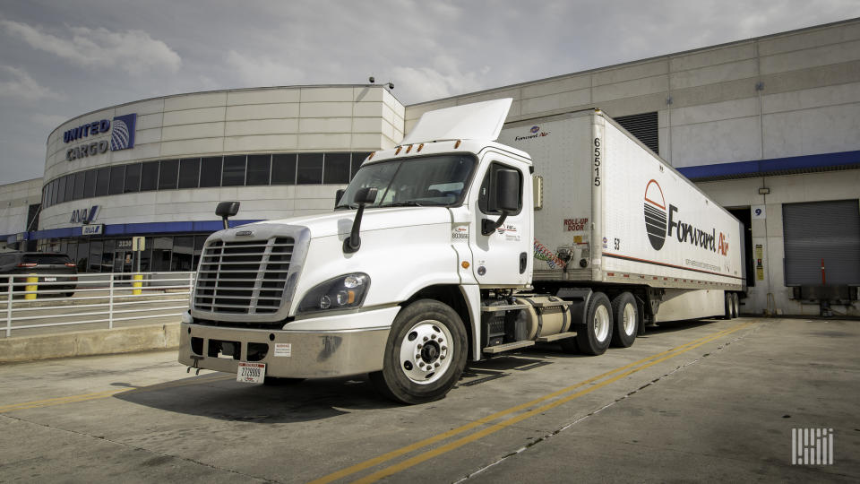 A Forward Air tractor-trailer backed up to a United Airlines cargo terminal