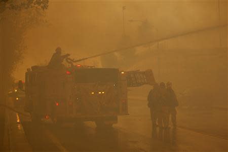 Firefighters protect homes as a wildfire driven by fierce Santa Ana winds blows in Rancho Cucamonga, California, April 30, 2014. REUTERS/David McNew