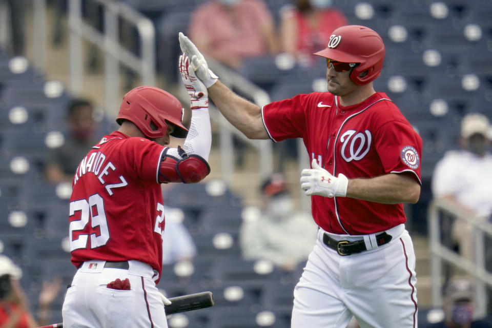 Washington Nationals' Ryan Zimmerman, right, is congratulated by teammate Yadiel Hernandez after hitting a solo home run during the third inning of a spring training baseball game against the Houston Astros Monday, March 1, 2021, in West Palm Beach, Fla. (AP Photo/Jeff Roberson)