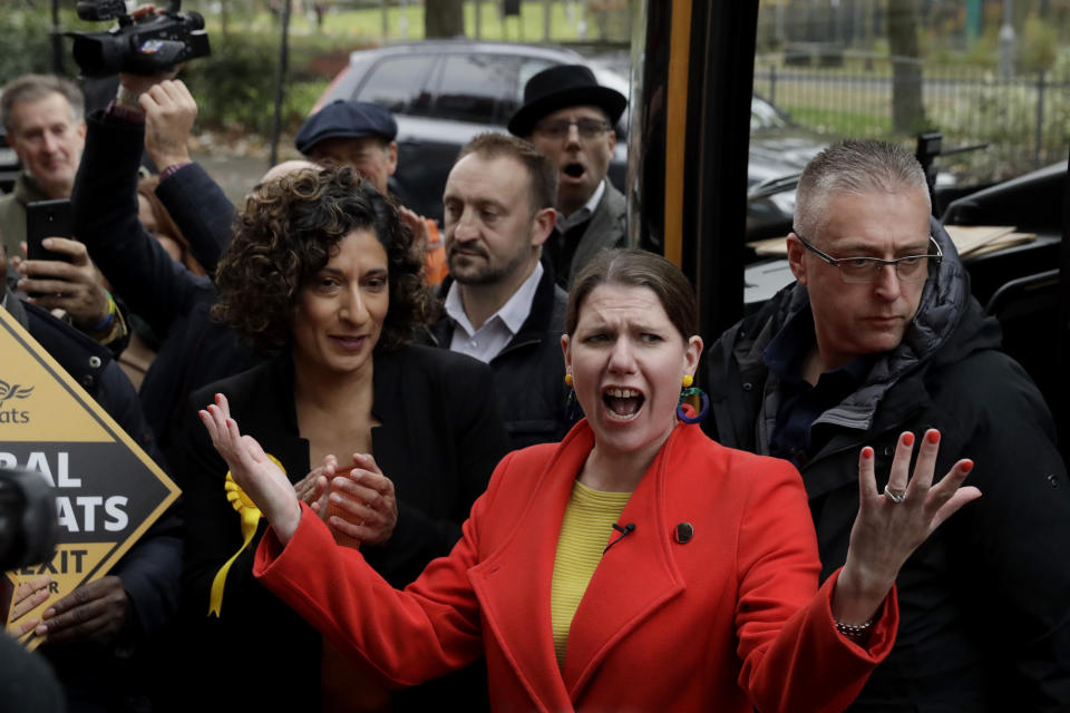 Britain's Liberal Democrats leader Jo Swinson reacts as she is greeted by supporters as she gets off her campaign bus and then stands flanked by Humaira Ali, left, the Liberal Democrats candidate for Southwark and Old Bermondsey as she arrives to campaign at Cafe Amisha in the Southwark and Old Bermondsey constituency in south London, Saturday, Nov. 16, 2019. (AP Photo/Matt Dunham)