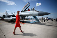 <p>An Aeroflot flight attendant walks by a Mikoyan MiG 29K fighter jet on display at the MAKS-2017 International Aviation and Space Salon in Zhukovsky, Moscow Region, Russia, July 18, 2017. (Photo: Sergei Bobylev/TASS via Getty Images) </p>