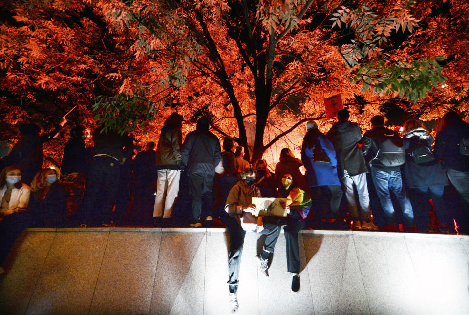 Protesters gather outside the parliament in Warsaw, Poland, Wednesday Oct. 28, 2020. People across Poland stayed off their jobs and huge crowds poured onto the streets for a seventh straight day of protests Wednesday, enraged over a top court ruling that bans abortions in cases of fetal abnormalities.(AP Photo/Czarek Sokolowski)