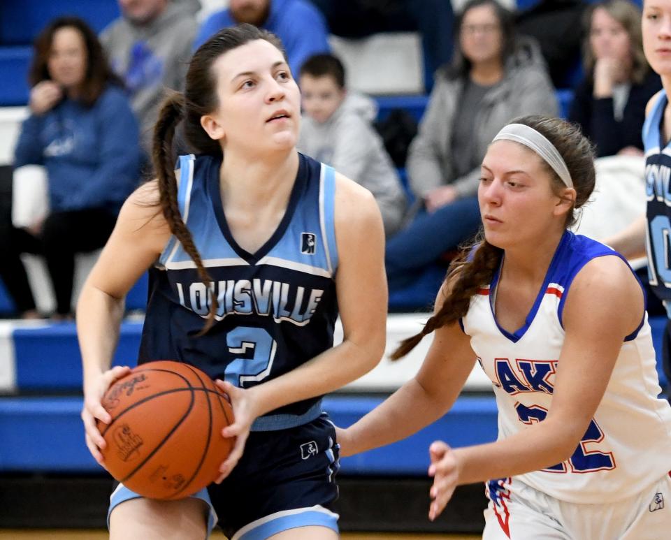 Louisville's Courtney Barwick looks for the basket under pressure from Lake's Alayna Horning in girls basketball at Lake   Saturday, February 04, 2023.