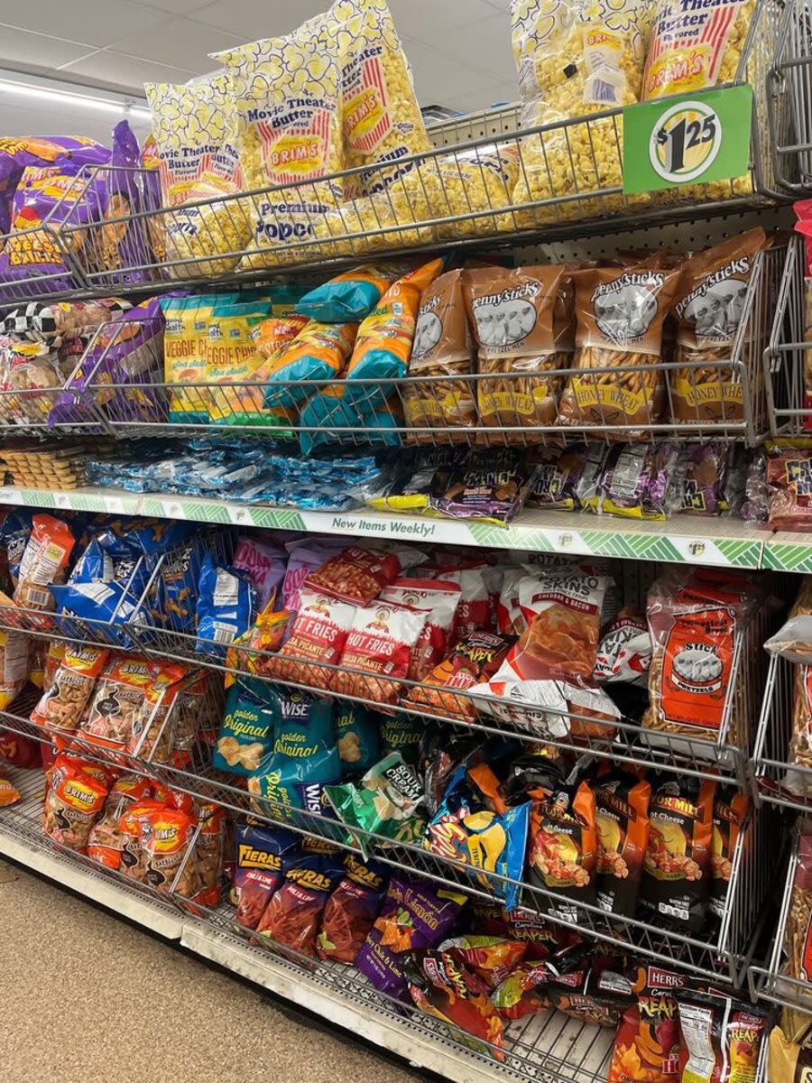 Snacks for sale in an aisle at a Dollar Tree in Jacksonville, Florida, six shelves filled with numerous different kinds of snacks