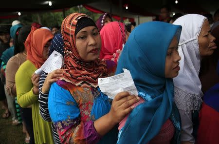 Villagers line up to vote in the country's presidential election at Bojong Koneng polling station in Bogor July 9, 2014. REUTERS/Beawiharta