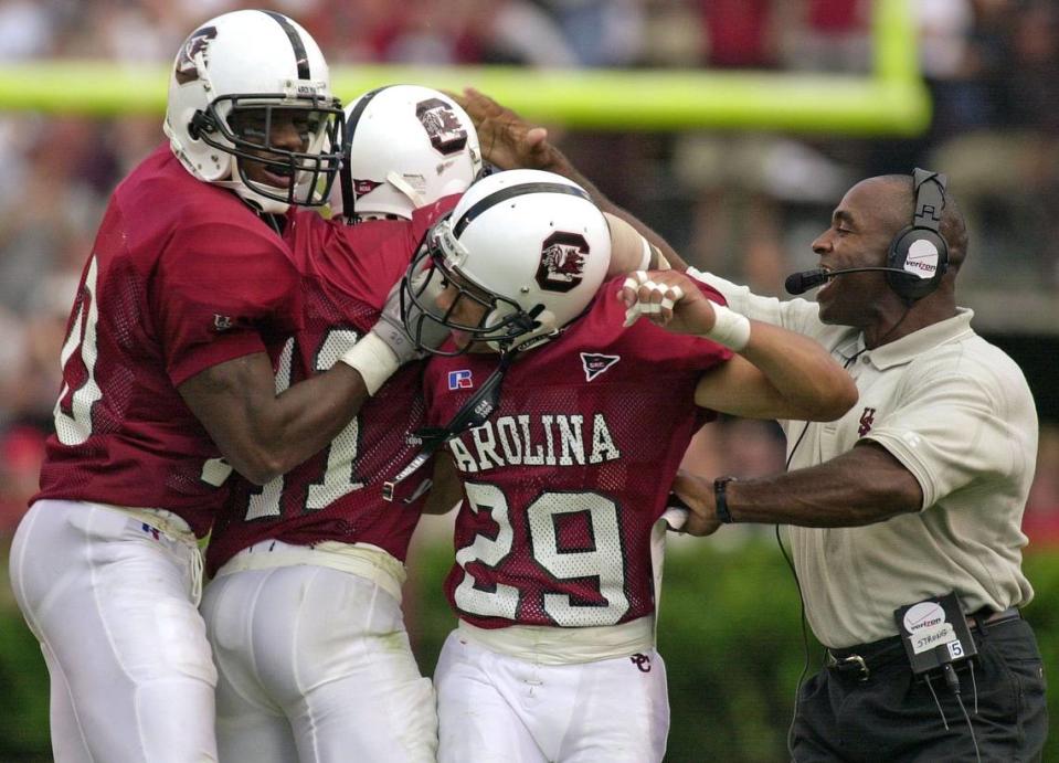 South Carolina’s Willie Offord (20), Rashad Faison (11) and Deandre Eiland (29) celebrate an interception with defensive coordinator Charlie Strong in the game where the Gamecocks upset the No. 9 ranked Georgia Bulldogs 21-10 on Sept. 9, 2000. UGA QB Quincy Carter was intercepted five times by the Gamecocks on the day.