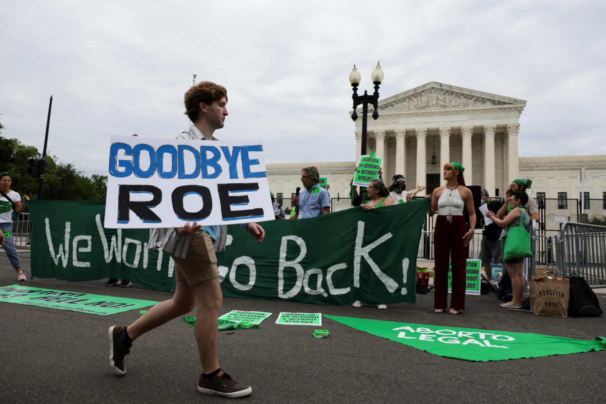An anti-abortion protester walks past abortion rights supporters 