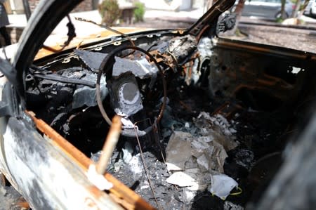 A burned car in the driveway of a suburban home that was the site of a hash oil extraction laboratory explosion is seen in the Mira Mesa area of San Diego