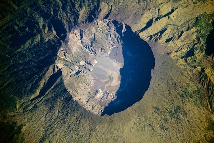 <span class="caption">Mount Tambora’s crater.</span> <span class="attribution"><a class="link " href="https://commons.wikimedia.org/wiki/File:Mount_Tambora_Volcano,_Sumbawa_Island,_Indonesia.jpg" rel="nofollow noopener" target="_blank" data-ylk="slk:Wikimedia Commons/NASA;elm:context_link;itc:0;sec:content-canvas">Wikimedia Commons/NASA</a></span>