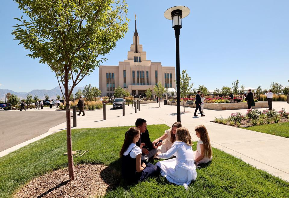 The Somers family sits on the grass after the first session of the dedication of the Saratoga Springs Utah Temple in Saratoga Springs, Utah, on Sunday, Aug. 13, 2023. | Scott G Winterton, Deseret News