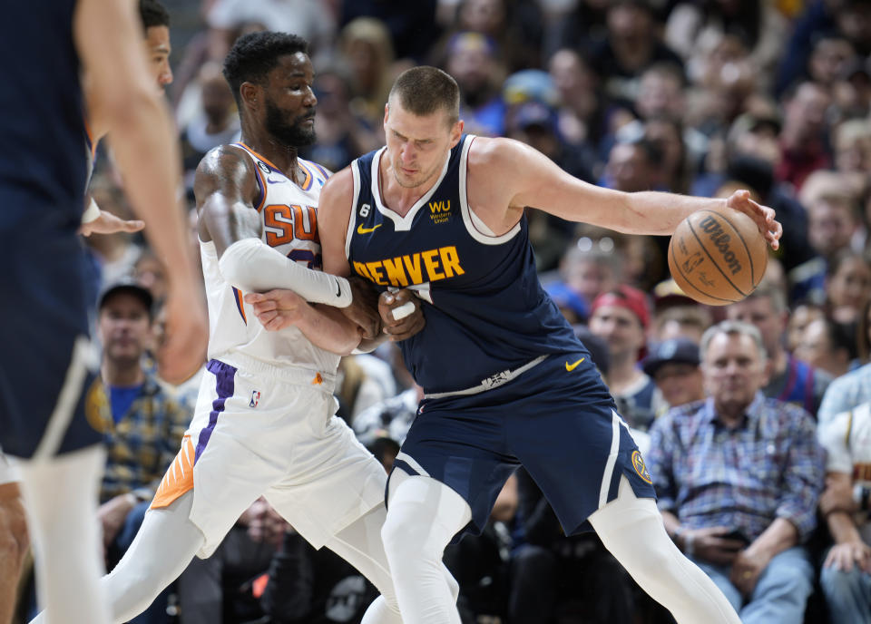 Denver Nuggets center Nikola Jokic, right, drives to the rim as Phoenix Suns center Deandre Ayton defends in the second half of Game 2 of an NBA second-round playoff series Monday, May 1, 2023, in Denver. (AP Photo/David Zalubowski)