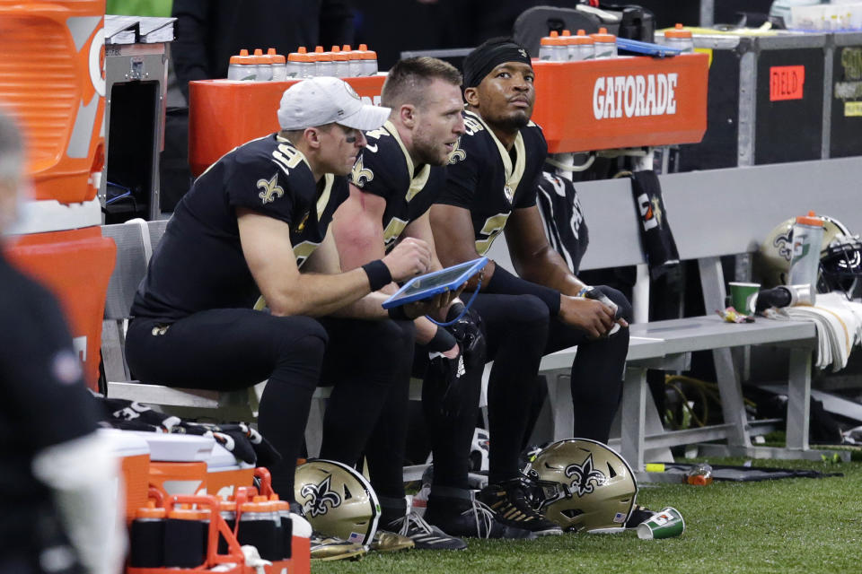 New Orleans Saints quarterbacks Drew Brees (9), Taysom Hill (7) and Jameis Winston (2), sit together on the bench in the second half of an NFL football game against the San Francisco 49ers in New Orleans, Sunday, Nov. 15, 2020. (AP Photo/Butch Dill)