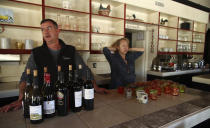 All Seasons restaurant chef Kevin Kathman, left, and owner Gayle Keller stand at the bar as they look at their empty business Monday, Oct. 15, 2018, in Calistoga, Calif. The restaurant was forced to close, losing an estimated $20,000 per day, as their power was cut off. Northern California's biggest utility has taken the unprecedented step of cutting electricity for tens of thousands of customers in an attempt to prevent wildfires amid rising winds and official warnings on Monday of extreme fire danger. (AP Photo/Ben Margot)