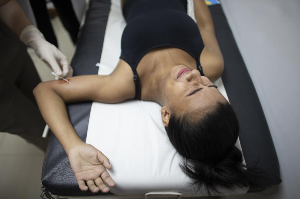 In this photo taken July 25, 2019, 18-year-old Yorselis Fajardo, who became a mother when she was 15, gets a hormonal implant on her arm to prevent pregnancies at a clinic in the Caucaguita neighborhood on the outskirts of Caracas, Venezuela. In a country where contraceptives are in short supply, word of the implants spread quickly, and while the lucky get on a list, the less fortunate hope there will be extras. (AP Photo/Ariana Cubillos)