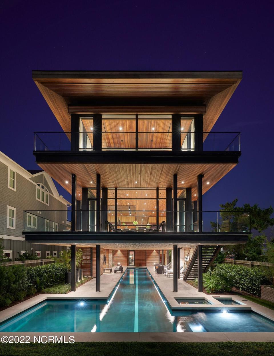 Multi-story home with pool underneath shown at night in North Carolina