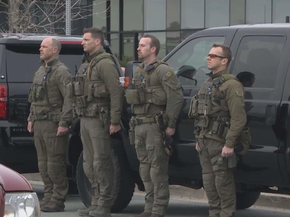 Cpl. Tim Mills, far left, had 20 years experience on the Nova Scotia RCMP's Emergency Response Team when he led the tactical unit responding to the April 2020 mass shooting. Cpl. Trent Milton is second from left. Days later, they stood at attention as the body of their colleague, Const. Heidi Stevenson, who was among the 22 people killed, passed by.  (CBC - image credit)