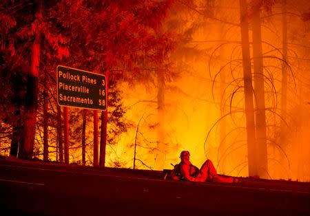 A firefighter battling the King Fire watches a backfire burn along Highway 50 in Fresh Pond, California September 16, 2014. REUTERS/Noah Berger