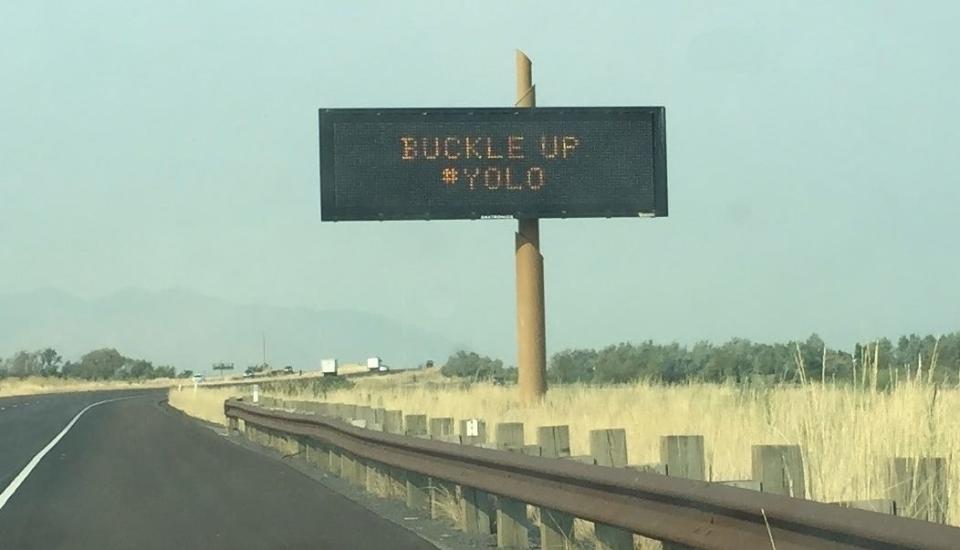 A Utah Department of Transportation roadside safety message saying: "Buckle up #YOLO."