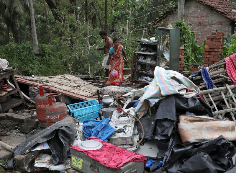 Residents salvage their belongings from the rubble of a damaged house in the aftermath of Cyclone Amphan, in South 24 Parganas