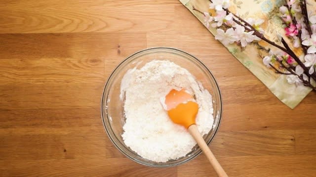 Mixed flour and cooking oil in glass bowl with spatula