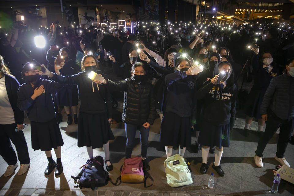 Protesters wave their smartphones as they sing "Glory to Hong Kong" during a rally for secondary school students near the Hong Kong Museum of Art in Hong Kong, Friday, Dec. 13, 2019. Protesters in Hong Kong wrote hundreds of Christmas cards on Thursday for people jailed in the city's pro-democracy movement, promising they won't be forgotten as they face spending the festive season behind bars. (AP Photo/Mark Schiefelbein)
