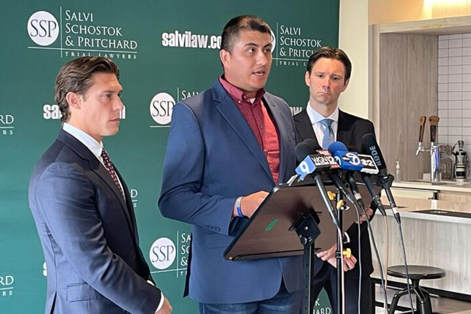 Former Northwestern University football player Ramon Diaz, flanked by attorneys Parker Stinar, left, and Patrick Salvi, right, speaks during a news conference in Chicago on Wednesday, Aug. 2, 2023, alleging widespread hazing among athletes. Diaz's lawsuit is the 10th to date against the school in Evanston, Illinois. (AP Photo/Claire Savage)