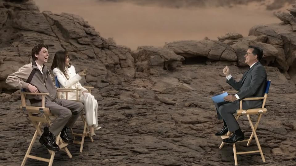 Stephen Colbert interviews Dune's Timothee Chalamet and Zendaya in front of a screen of Arrakis