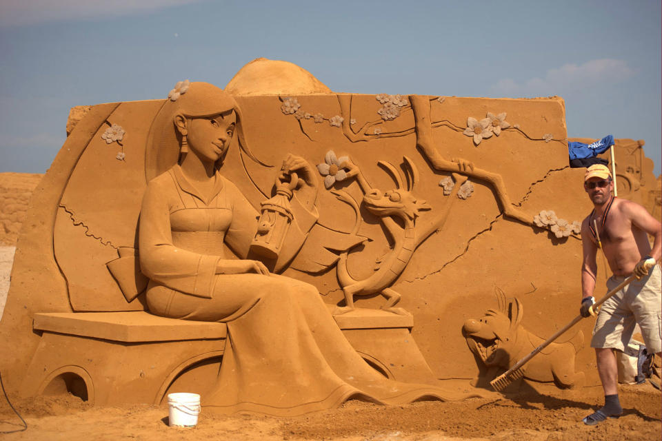 <p>A sand carver works on a sculpture during the Sand Sculpture Festival “Disney Sand Magic” in Ostend, Belgium. (Photo courtesy of Disneyland Paris) </p>