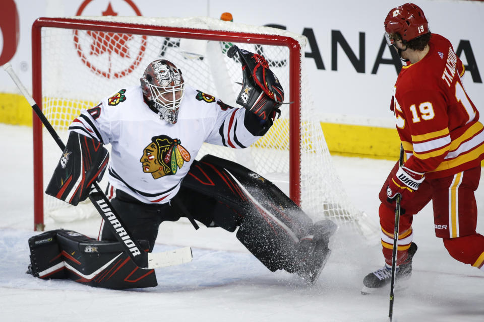 Chicago Blackhawks goalie Robin Lehner, left, manages to tip the puck away as Calgary Flames' Matthew Tkachuk watches during the second period of an NHL hockey game Tuesday, Dec. 31, 2019, in Calgary, Alberta. (Jeff McIntosh/The Canadian Press via AP)