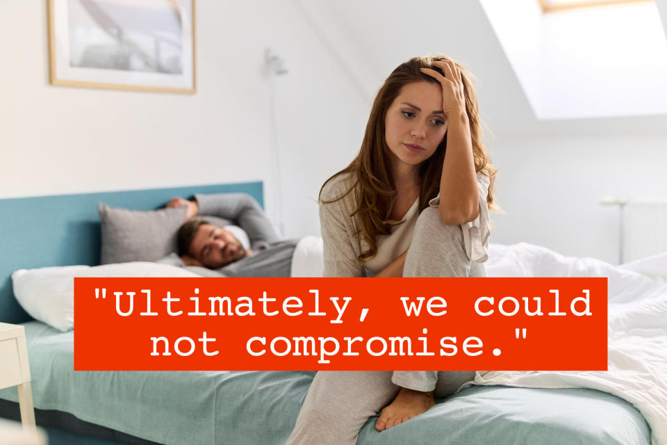 woman sitting up in bed feeling upset while a man sleeps obliviously