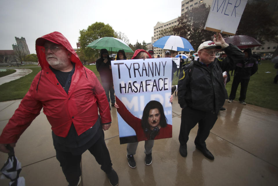 Protesters hold a sign showing Michigan Gov. Gretchen Whitmer during a rally against Michigan’s coronavirus stay-at-home order at the State Capitol in Lansing, Mich., Thursday, May 14, 2020. (AP Photo/Paul Sancya)