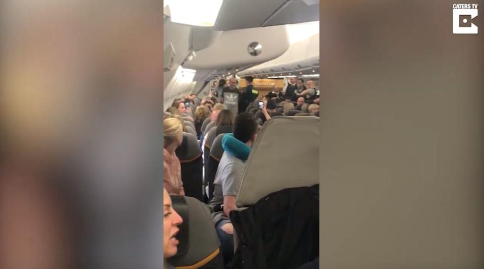 Plane passengers clapped and cheered as the group were led off the flight (Caters)