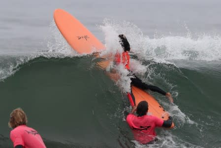 A surfer is wiped out by a wave on a Doyle surfboard in Malibu